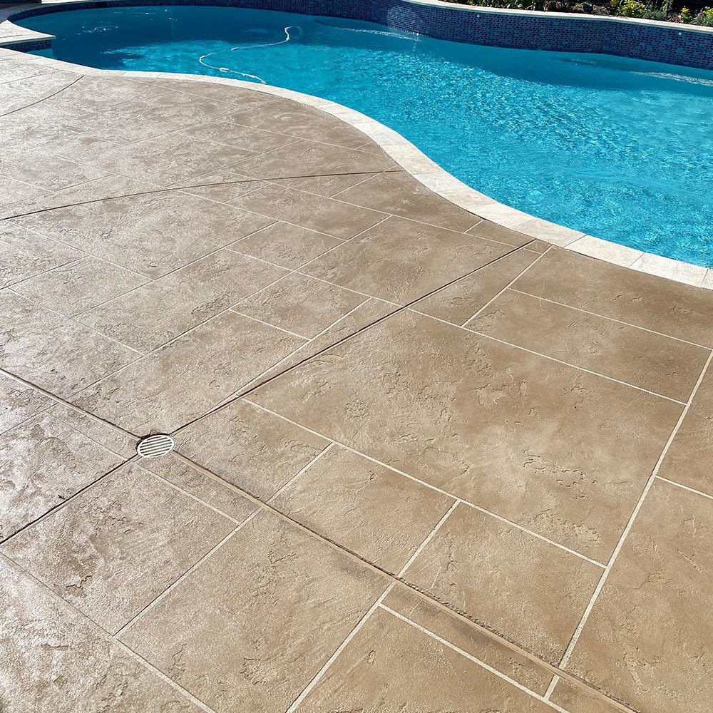 A close-up view of a pool deck featuring a durable and slip-resistant LimeCoat overlay, showcasing a textured and stylish design as part of Houston Pool Renovations' deck coating services.